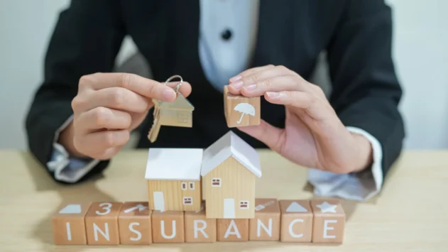 Holding Keys Over Insurance Letter Blocks
