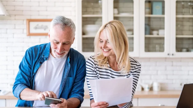 Retired Couple Budgeting With Calculator And Spreadsheet